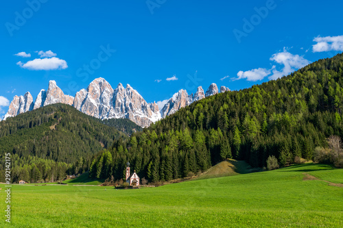 San Giovanni Church with background of rocky Dolomites peaks in Santa Magdalena Italy