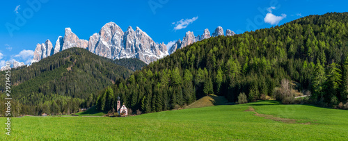 Panorama view of San Giovanni Church with background of rocky Dolomites peaks in Santa Magdalena Italy photo