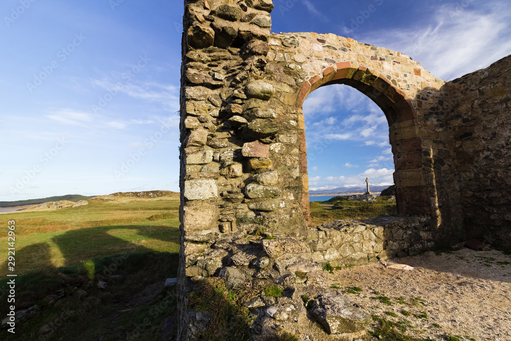 View of the remains of St Dwynwen's Church on Llanddwyn Island with the Snowdonia Mountain Range behind, Newborough Warren National Nature Reserve, Anglesey, North Wales