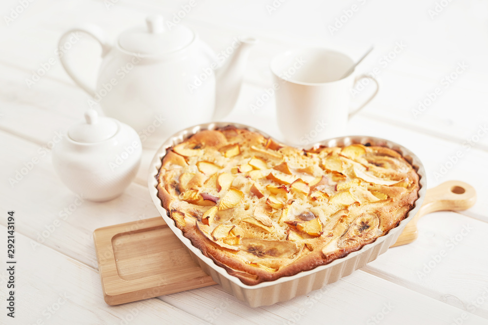 pie with banana, apples and nectarine on a white wooden background