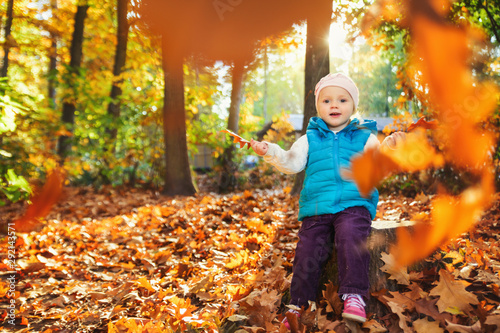 little girl is playing outdoors in autumn