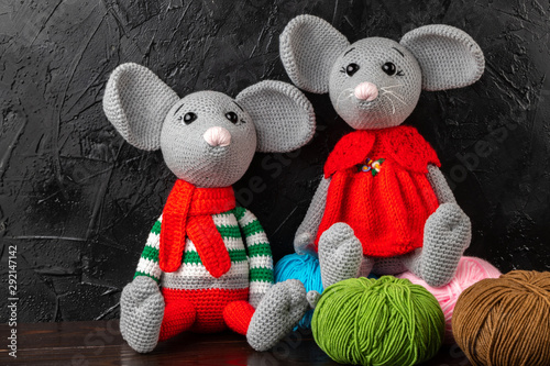 Two funny knitted toy rats on a dark background, a symbol of the New Year 2020.  Amigurumi toy. Crochet stuffed animals.