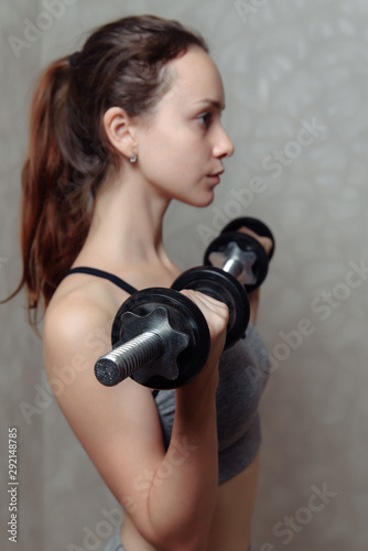 Beautiful woman lifting dumbbell in home. She training biceps © bo.kvk