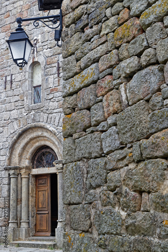 Old church entrance in the medieval village of La Garde Guerin, in Lozere, France