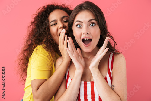 Image of amazing multinational girls wondering while talking secrets or gossips