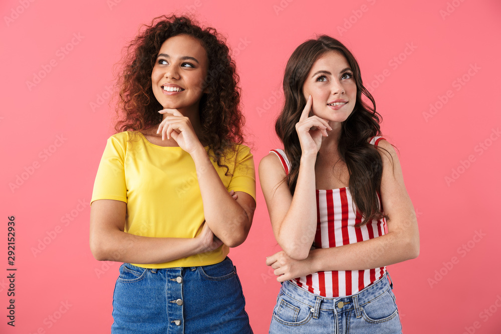 Image of alluring multinational girls smiling and looking aside at copyspace Image of alluring multinational girls smiling and looking aside at copyspace