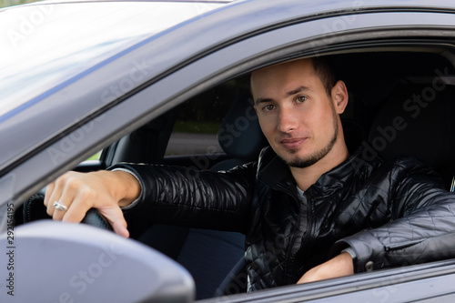 young man in a car on a city street