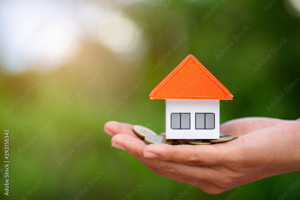 Orange roof houses and coins are in the hands of businessmen. The concept of home insurance insures property. A businessman who protects an orange house Protecting a house Saving money buying a house. Orange roof houses and coins are in the hands of businessmen. The concept of home insurance insures property. A businessman who protects an orange house Protecting a house Saving money buying a house.