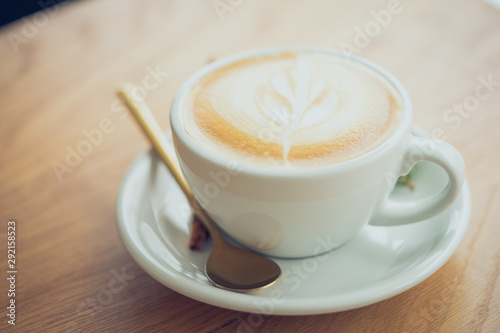 white coffee mug. Coffee is a latte. table on the wooden table in vintage style, taken from the top view, see the froth of milk foam.