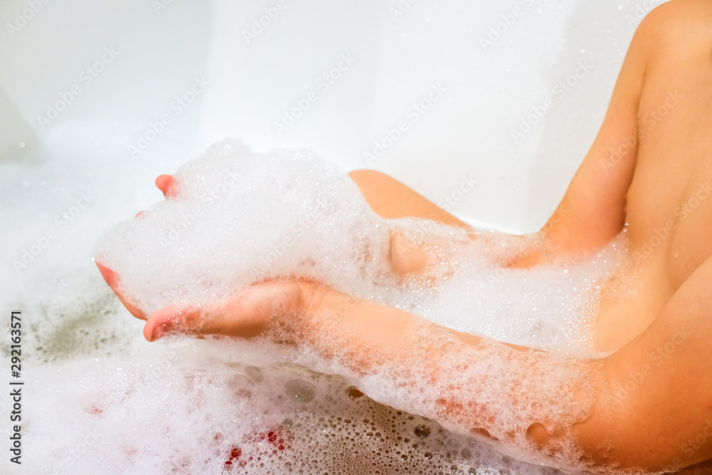 Child takes a bath with a lot of foam to clean his body, concept of child hygiene. Child takes a bath with a lot of foam to clean his body, concept of child hygiene.