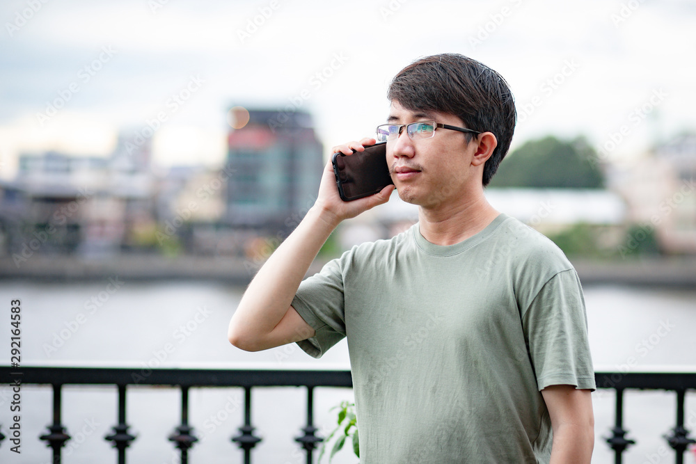 Man calling phone on the riverside view point