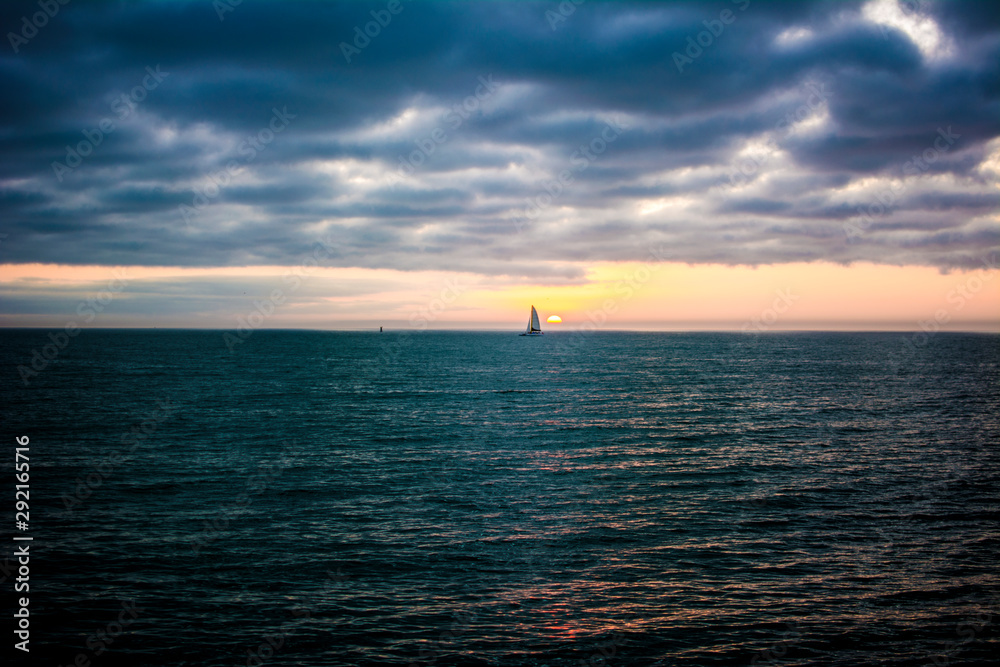 sunset at sea with sailboat