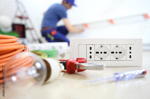Billede på lærred electrician work with electrical equipment in the foreground, bulb, tools and so