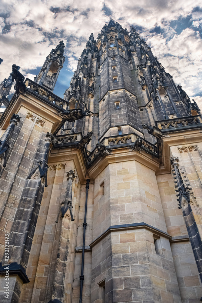 View from below on tall ancient the St. Vitus Cathedral with cloud sky in Prague