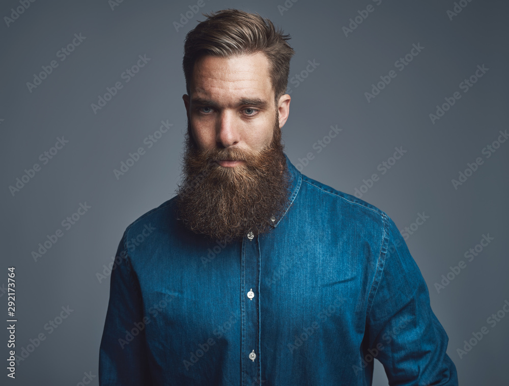Obraz premium Bearded young man praying against a gray background