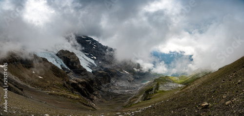 landscape at Hohtürli with Oeschinensee in the distance in misty clouds while hiking photo