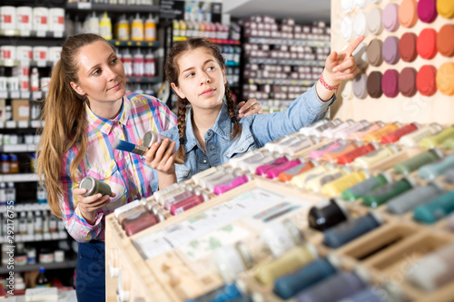 Mother and daughter holding jar with color paint