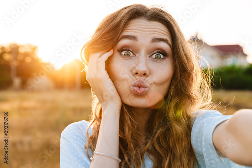 Photo of funny caucasian woman taking selfie photo and making kiss lips