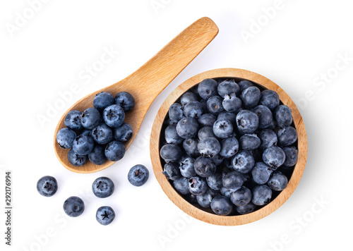 Billede på lærred Blueberries in wood bowl and spoon  isolated on white background