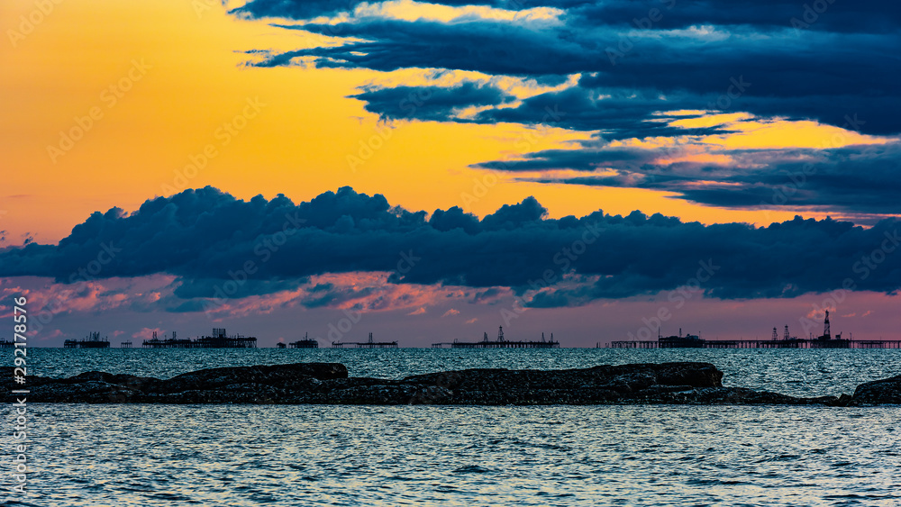 Oil platforms in the sea at sunset