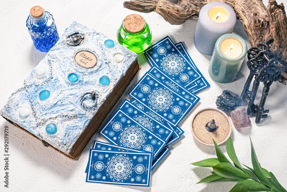 Tarot cards and white magic book on the white table background.