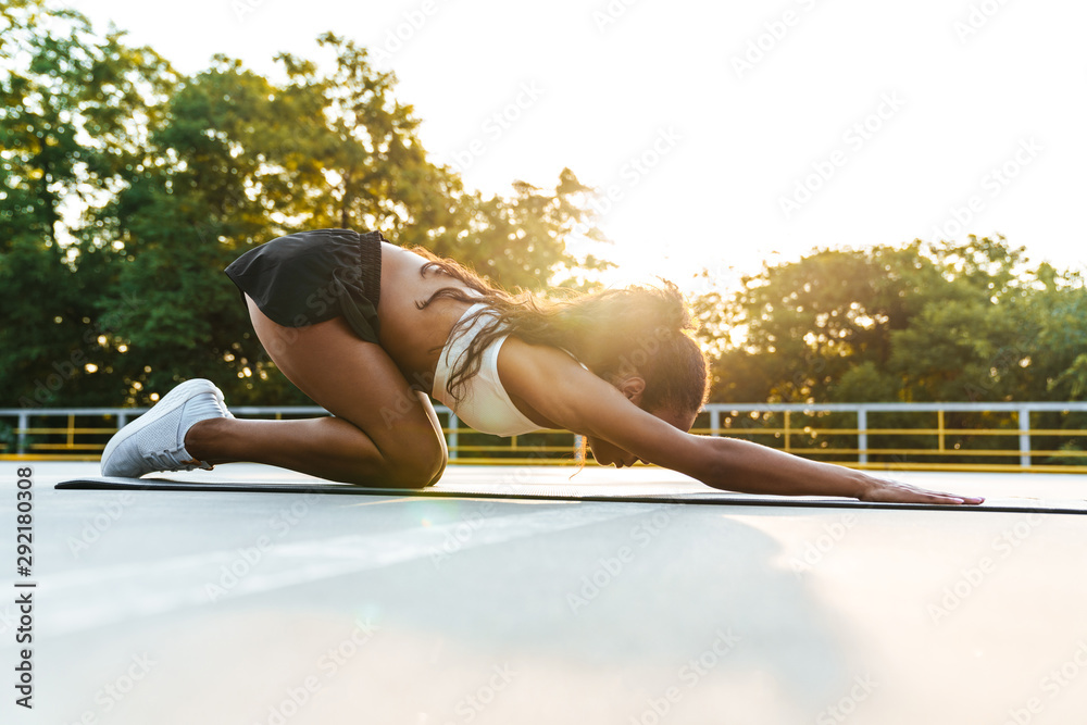 Photo of brunette slim woman doing exercise on mat