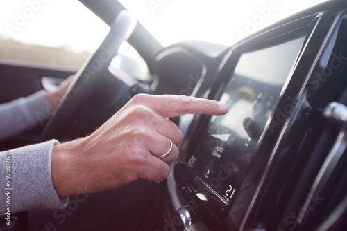 Man using navigation system while driving a car. Transport, destination, modern technology and people concept - male hand searching for route using navigation system on car dashboard screen.