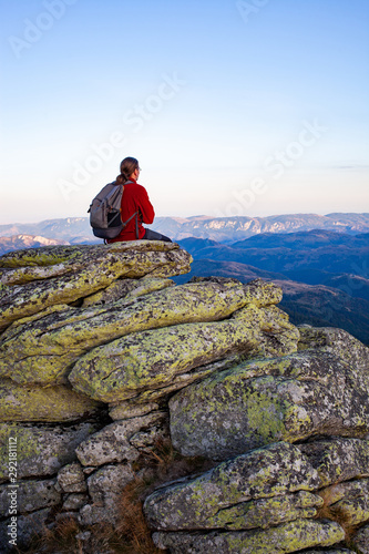 male hiker standing on rock formations taking photos