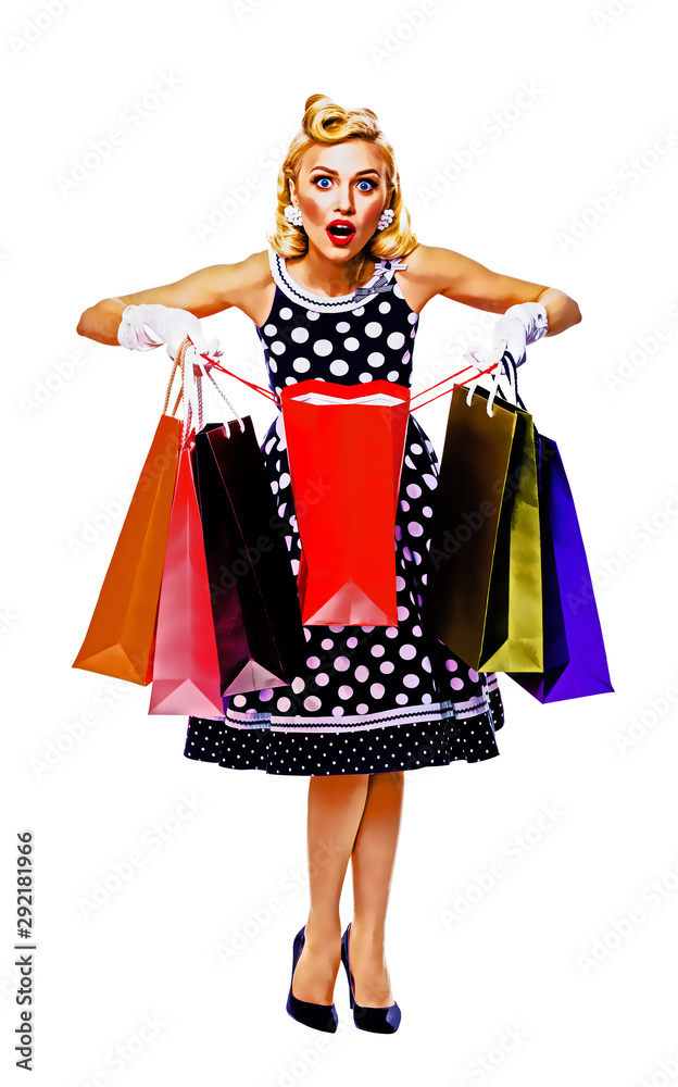 Full body of happy excited woman in pin up style dress in polka dot, holding shopping bags, isolated over white
