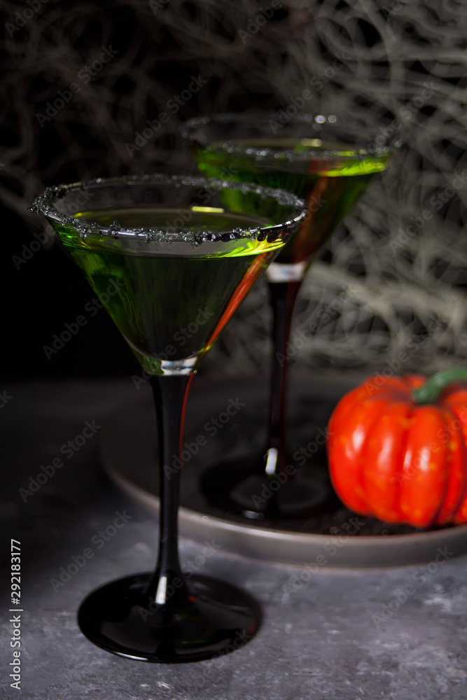 Two glasses with green zombie cocktail for Halloween party on the dark background