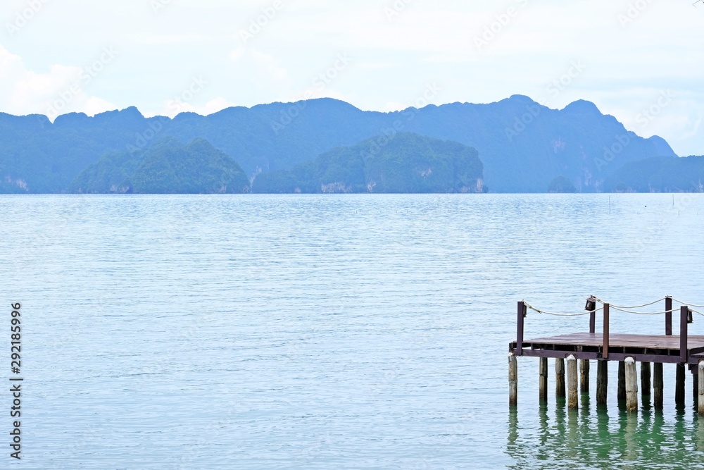 Peaceful waterfront with sea and mountains as background.