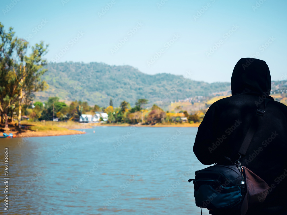 spring season activity concept from backside traveler or photographer man in warm suit stand and see lake view in morning time spring season activity concept from backside traveler or photographer man in warm suit stand and see lake view in morning time