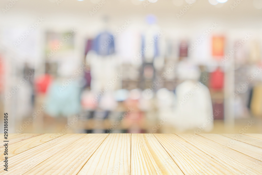 Empty wood table top with modern clothing store interior blur abstract defocused background with bokeh light for product display