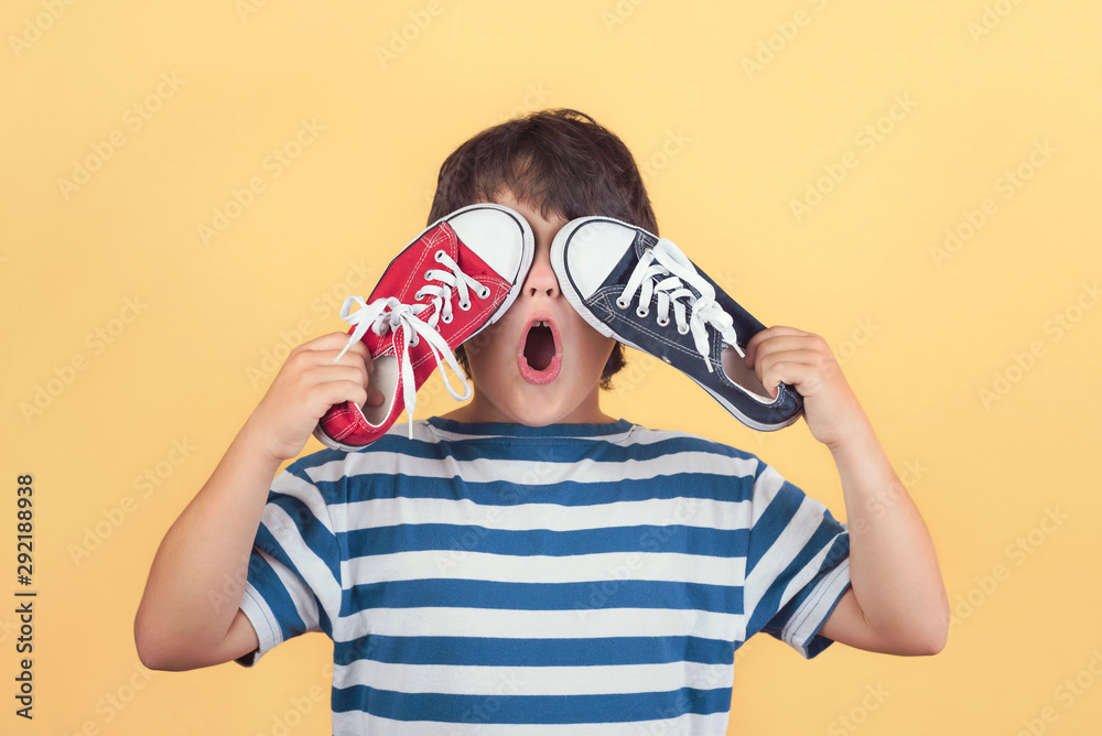 Funny child who covers an eyes with a sneakers Funny child who covers an eyes with a sneakers