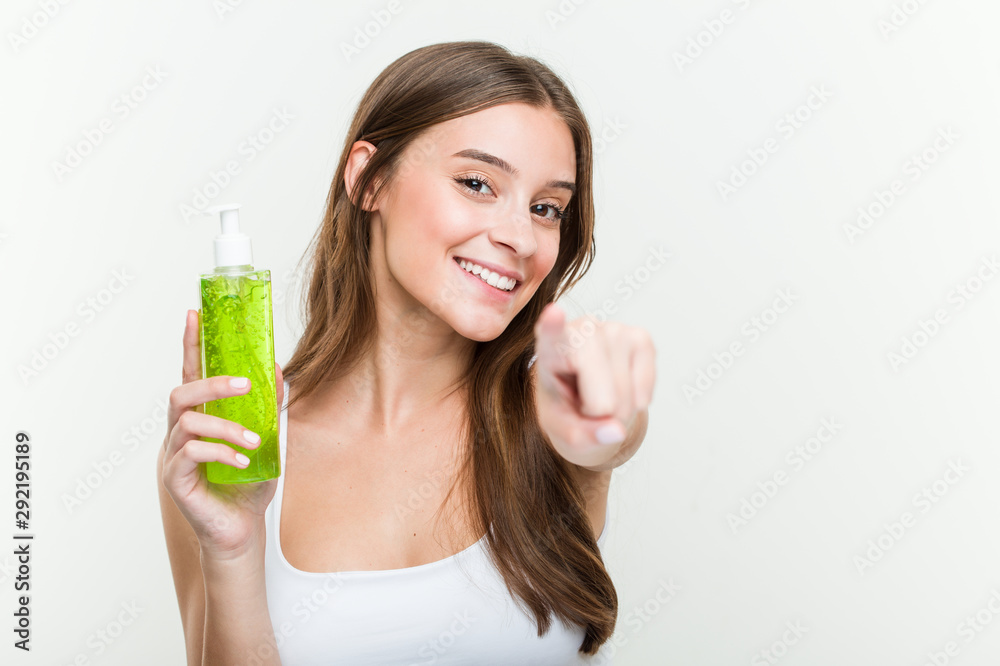 Young caucasian woman holding an aloe vera bottle cheerful smiles pointing to front. Young caucasian woman holding an aloe vera bottle cheerful smiles pointing to front.