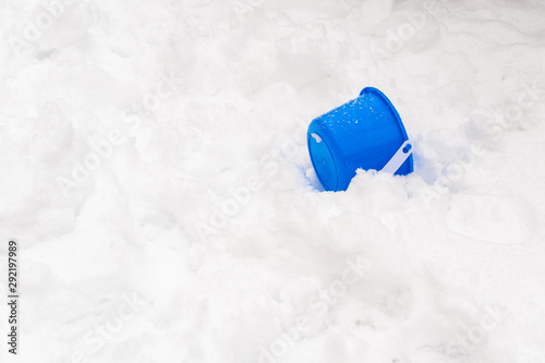 A single blue bucket in the snow photo