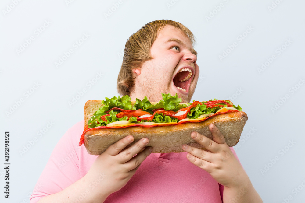 Caucasian crazy blond fat man holding a giant sandwich Caucasian crazy blond fat man holding a giant sandwich