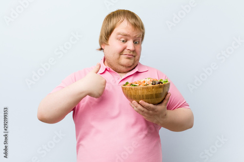 Caucasian crazy blond fat man holding a salad bowl