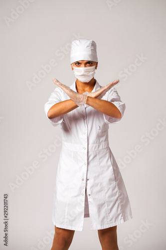 Nurse in a white suit isolated on gray background photo