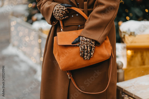 Outdoor fashion portrait of plus size woman wearing trendy animal, leopard print. Concept of autumn and winter clothes, outfit for glamour woman in city. Background of Christmas decorations. Copy