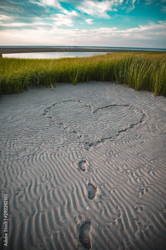 footprints in the sand forming a heart