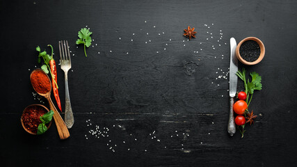 The background of cooking. On a black wooden background. Top view. Free space for your text.