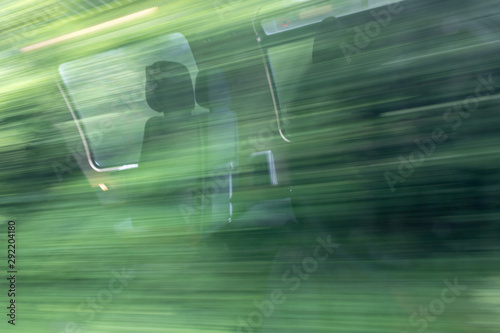 blurry abstract green landscape and seat reflections seen from train window in motion