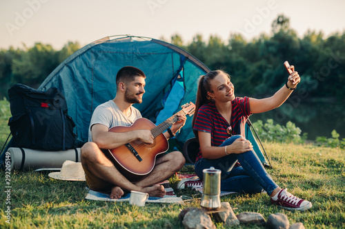 young happy couple camping together outdoor by the river