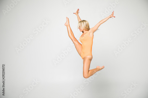 Young girl doing gymnastics exercise isolated over white background