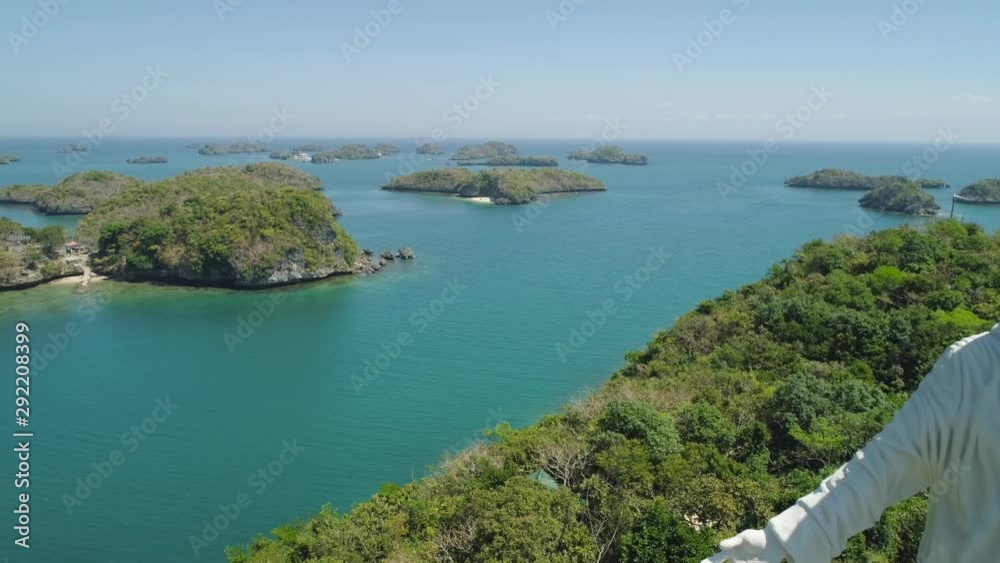 Statue of Jesus Christ on Pilgrimage island in Hundred Islands National Park, Pangasinan, Philippines. Aerial view of group of small islands with beaches and lagoons, famous tourist attraction Statue of Jesus Christ on Pilgrimage island in Hundred Islands National Park, Pangasinan, Philippines. Aerial view of group of small islands with beaches and lagoons, famous tourist attraction