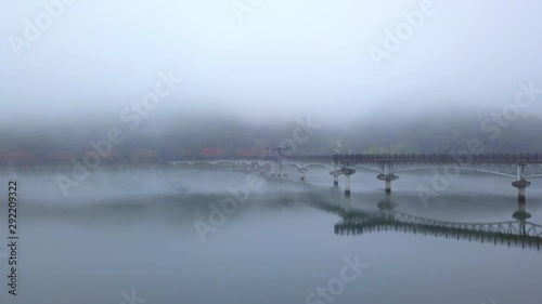 Aerial video of Wolyeonggyo bridge is located in the midst of Nakdong river in the morning during Autumn season at Andong city, South Korea. photo