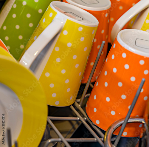 Colorful cups with white dots in a dishwasher.