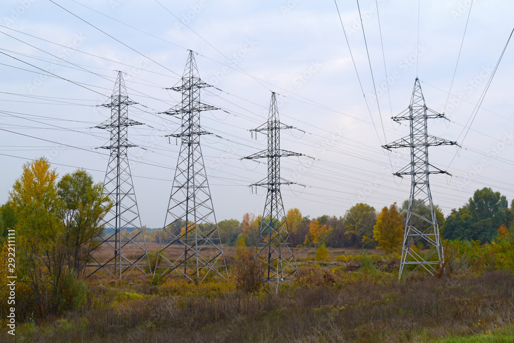 High voltage poles in the field in nature in autumn.
