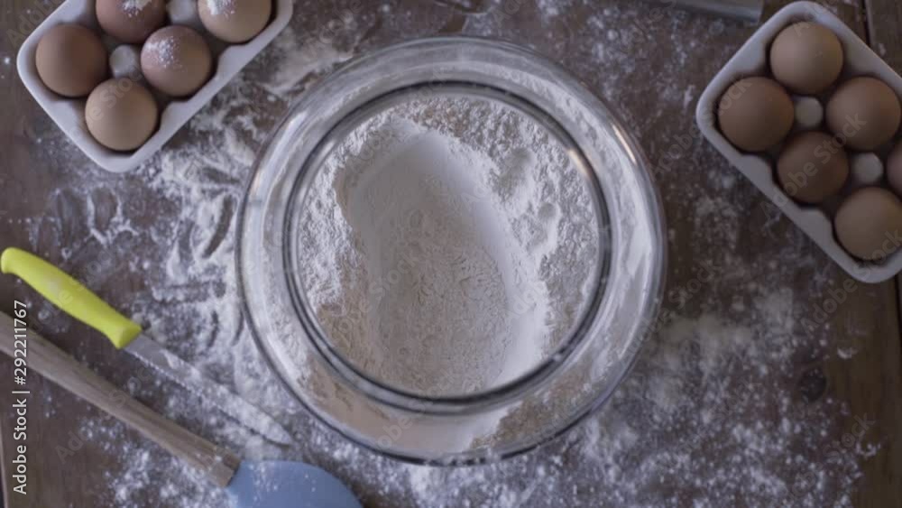Overhead Shot of Flour Jar as Hand Reaches in to Take a Scoop Overhead Shot of Flour Jar as Hand Reaches in to Take a Scoop
